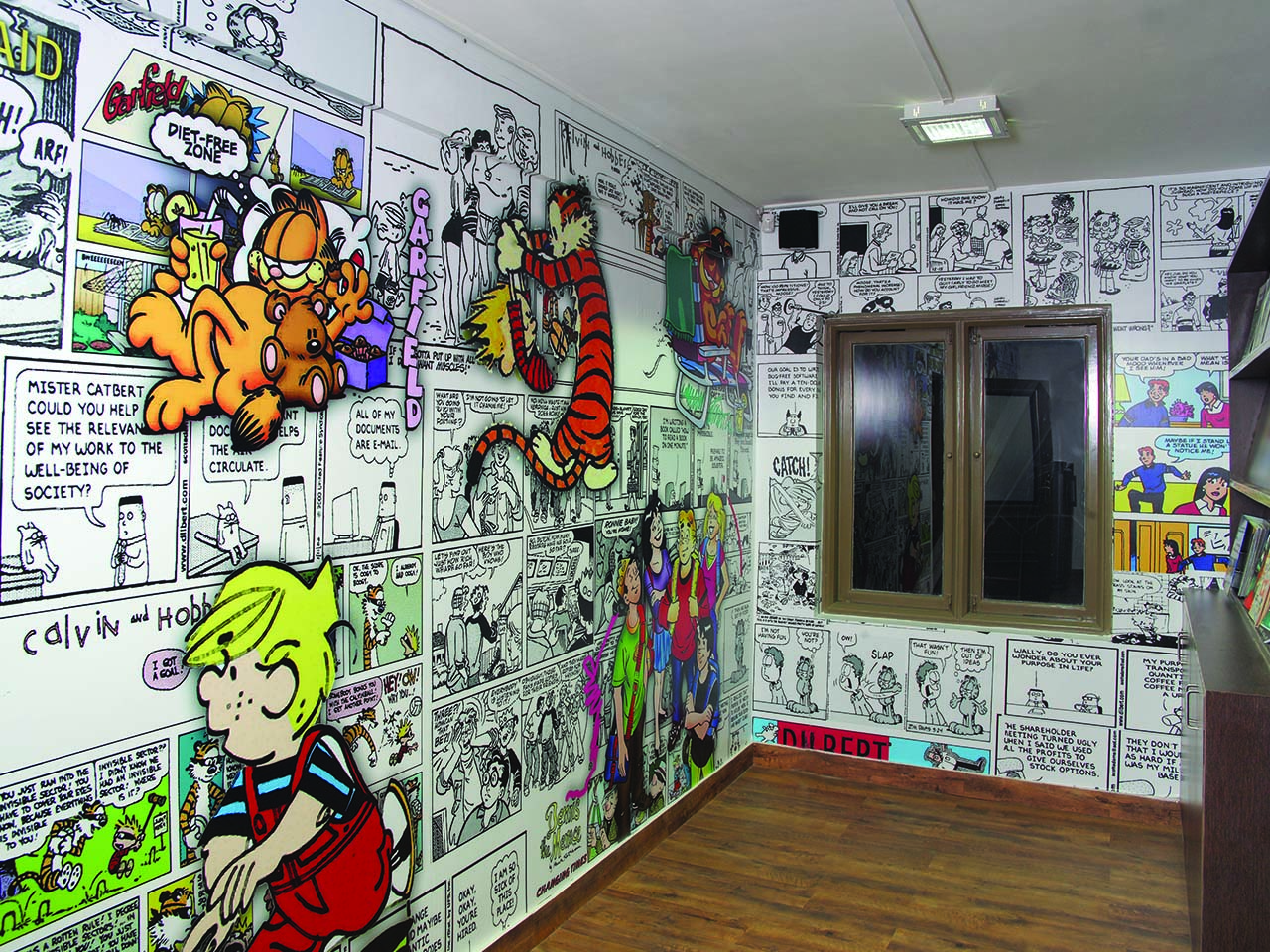 Cafetaria wall at Vastram office designed by StudioJ displaying different characters such as Garfield 